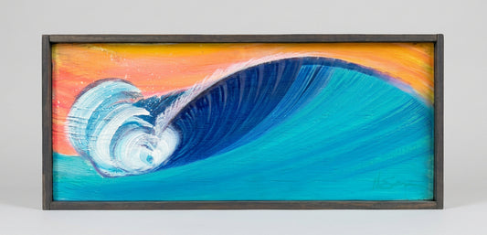 A framed painting of a large curling ocean wave, with bright blue and turquoise water, a white crest, and an orange sky, set in a dark frame against a light gray background.