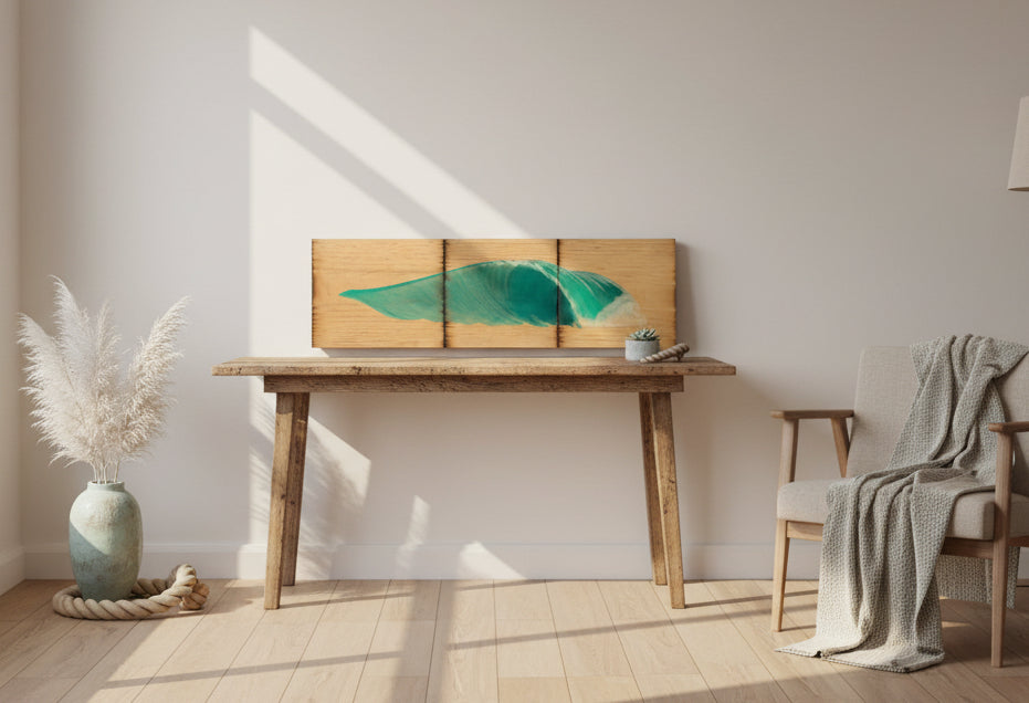 A three-panel wooden wall art piece featuring a painted turquoise ocean wave on a light natural wood background, shown against a plain light gray wall.