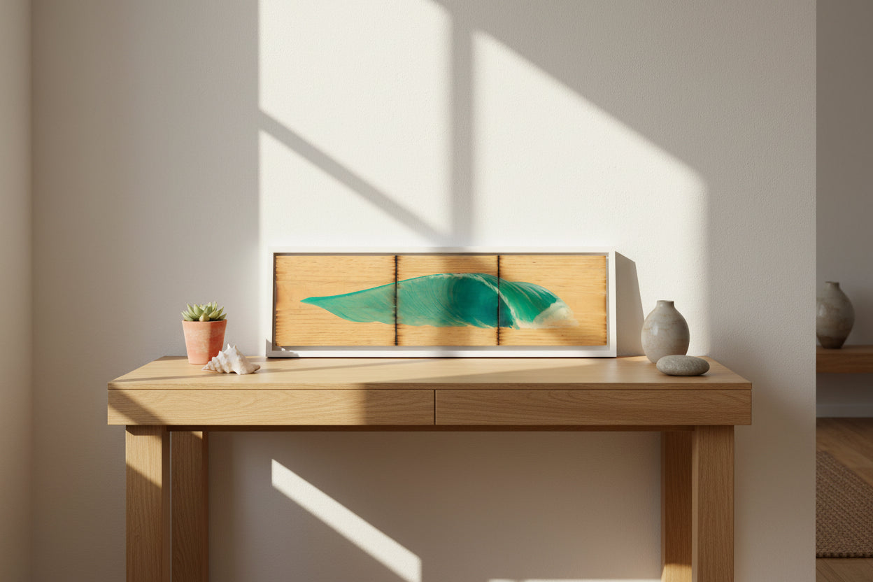 A three-panel wooden wall art piece featuring a painted turquoise ocean wave on a light natural wood background, shown against a plain light gray wall.